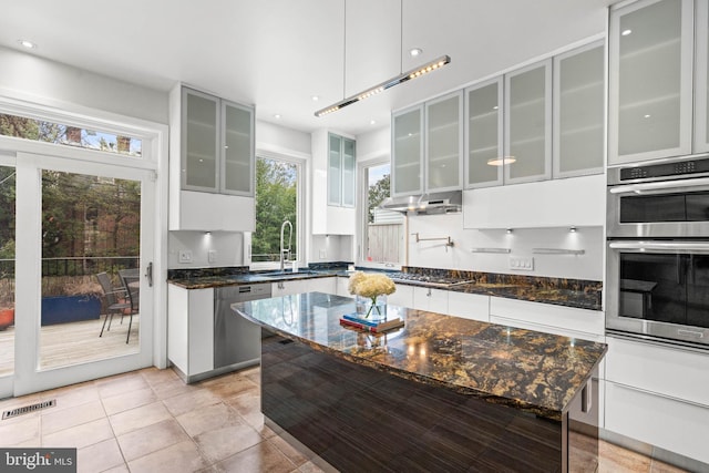 kitchen with light tile patterned floors, stainless steel appliances, visible vents, white cabinets, and a sink