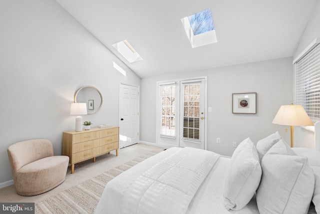 bedroom with vaulted ceiling with skylight, light colored carpet, baseboards, and multiple windows