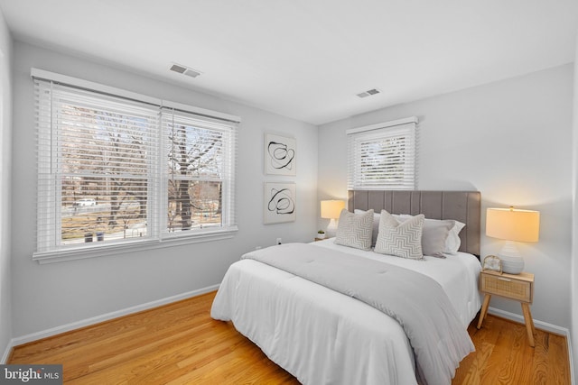 bedroom featuring visible vents, baseboards, and wood finished floors