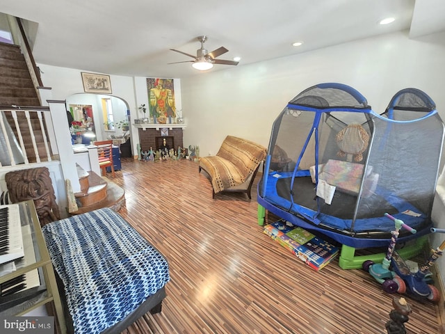 interior space featuring arched walkways, recessed lighting, a ceiling fan, and wood finished floors