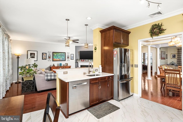 kitchen featuring visible vents, appliances with stainless steel finishes, open floor plan, a sink, and ornate columns