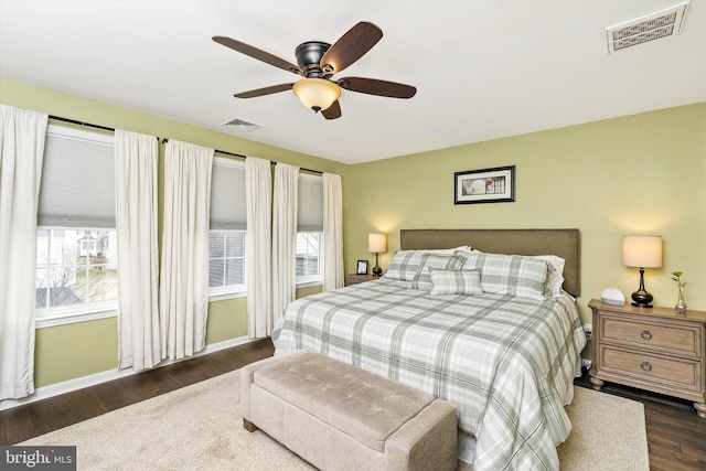 bedroom with ceiling fan, visible vents, and dark wood-type flooring