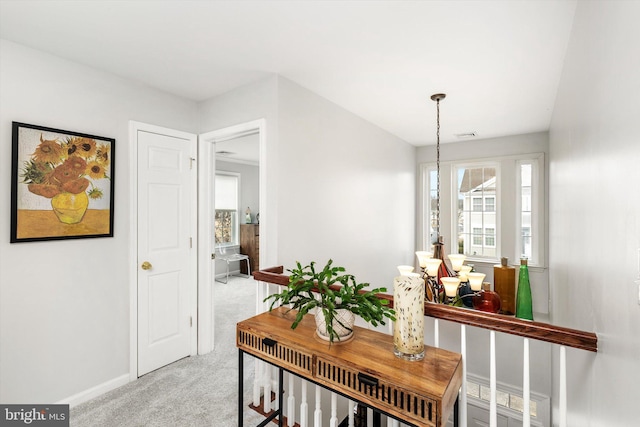 corridor featuring an upstairs landing, baseboards, and light colored carpet