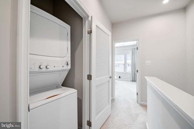 laundry area with baseboards, light colored carpet, laundry area, recessed lighting, and stacked washing maching and dryer