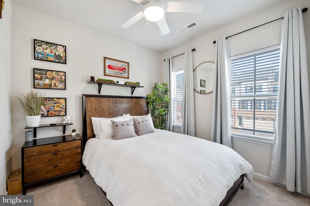 bedroom with ceiling fan, light colored carpet, visible vents, and baseboards