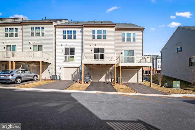 view of front of home featuring an attached garage, central AC unit, and driveway