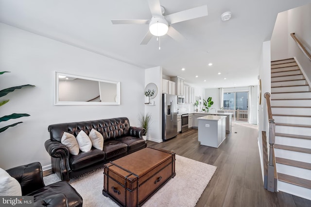 living room with a ceiling fan, baseboards, dark wood finished floors, recessed lighting, and stairs