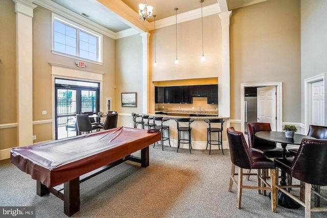 recreation room with carpet, pool table, crown molding, decorative columns, and a towering ceiling