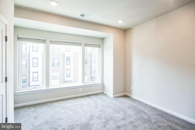 unfurnished room with carpet, visible vents, baseboards, and recessed lighting