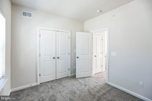 unfurnished bedroom with carpet, a closet, visible vents, and baseboards