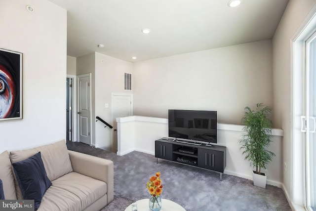 carpeted living room featuring baseboards, visible vents, and recessed lighting