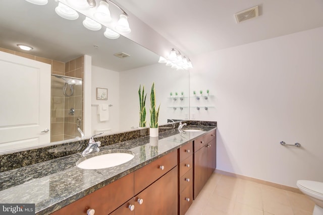 bathroom featuring toilet, double vanity, a sink, and visible vents