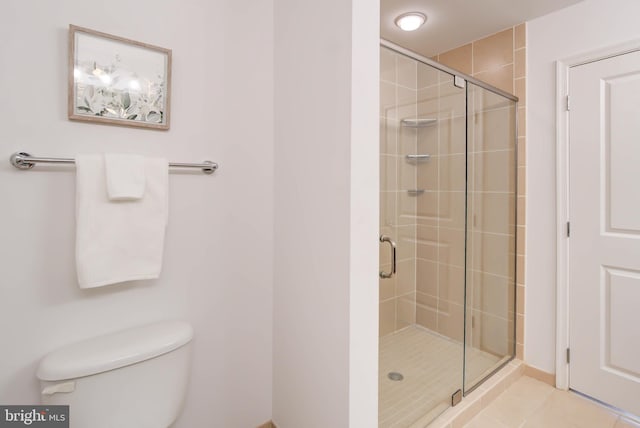 full bathroom with a stall shower, toilet, and tile patterned floors