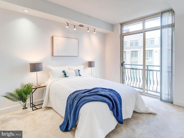 bedroom featuring carpet floors, access to exterior, expansive windows, and baseboards