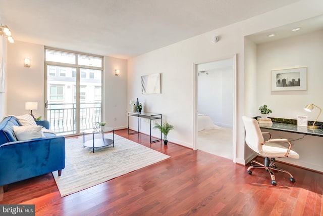 living room featuring a wall of windows, wood finished floors, and baseboards