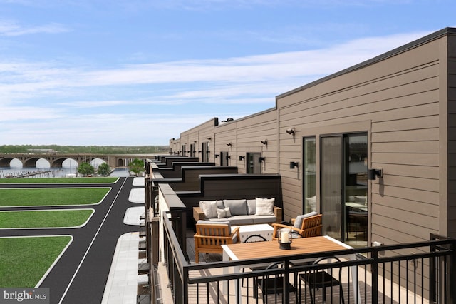 balcony featuring an outdoor hangout area and a water view