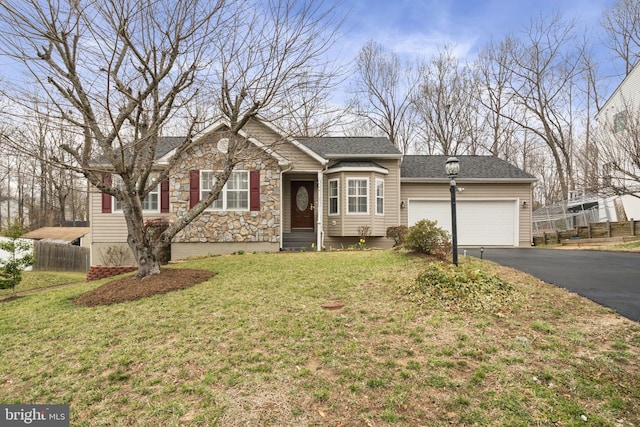 ranch-style home with fence, aphalt driveway, a front yard, a garage, and stone siding