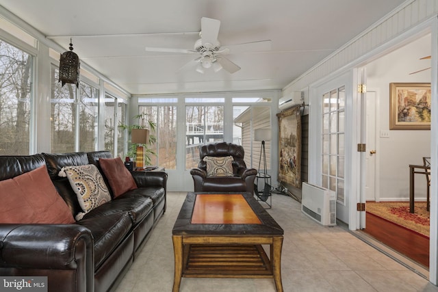 sunroom with a wealth of natural light, a wall mounted air conditioner, and ceiling fan