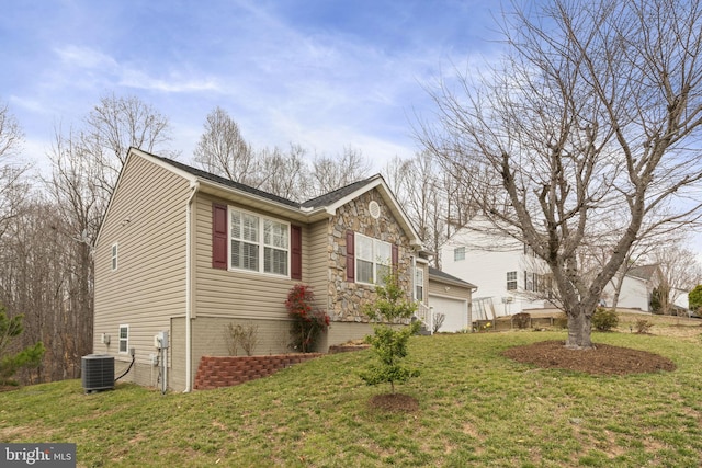 view of side of property featuring a garage, central AC unit, a yard, and stone siding