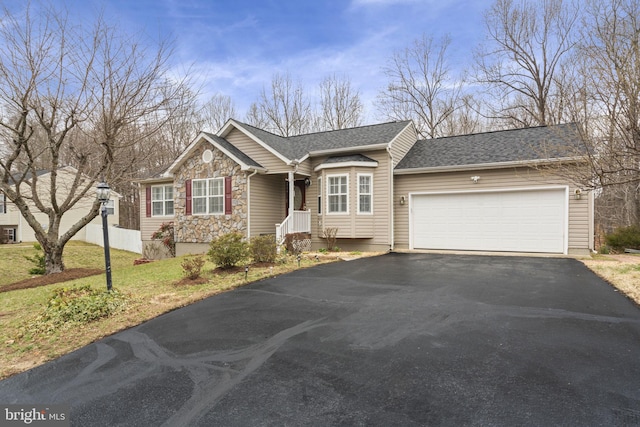 single story home with aphalt driveway, stone siding, a front yard, a shingled roof, and a garage