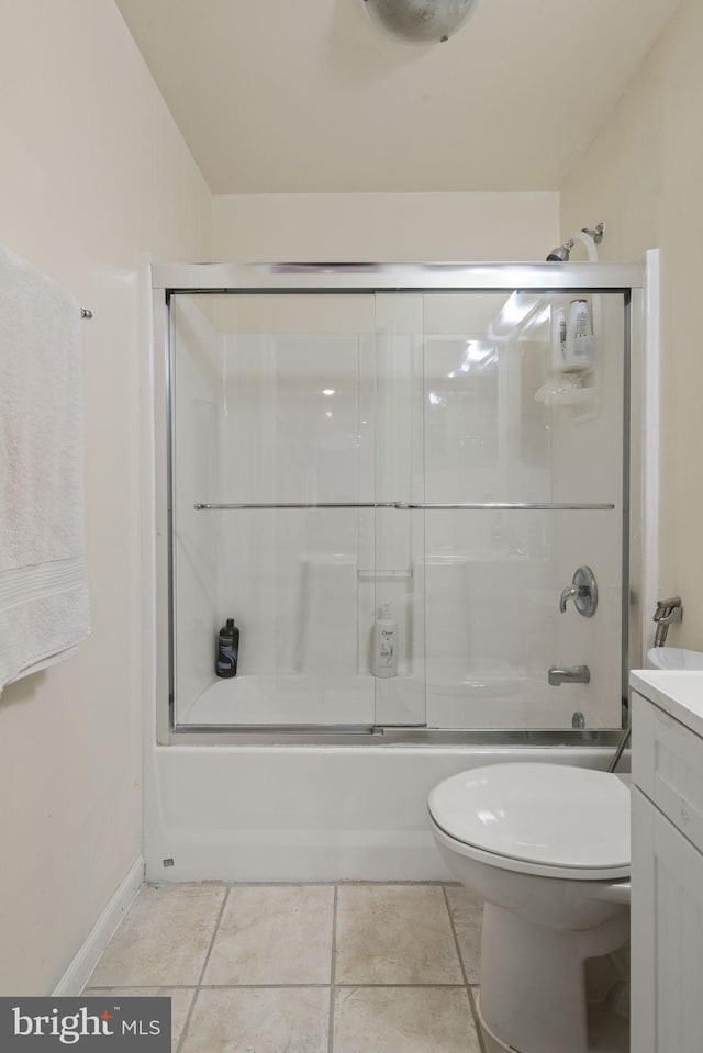 bathroom with combined bath / shower with glass door, toilet, vanity, and tile patterned flooring