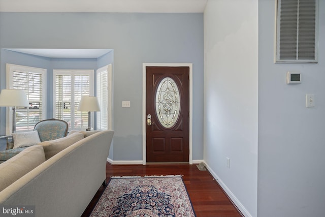 foyer entrance with visible vents, baseboards, and wood finished floors