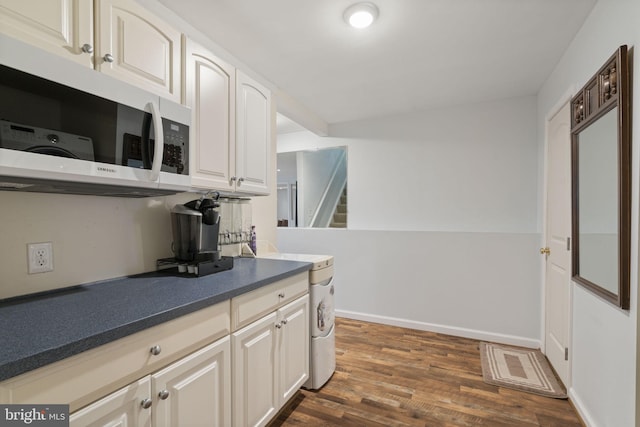 kitchen with baseboards, visible vents, dark wood-style flooring, white cabinetry, and dark countertops