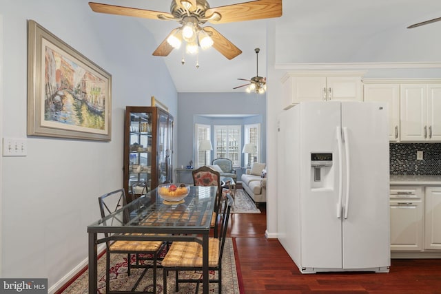 dining area featuring baseboards, lofted ceiling, a ceiling fan, and dark wood-style flooring