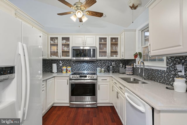 kitchen featuring dark wood finished floors, decorative backsplash, stainless steel appliances, and a sink