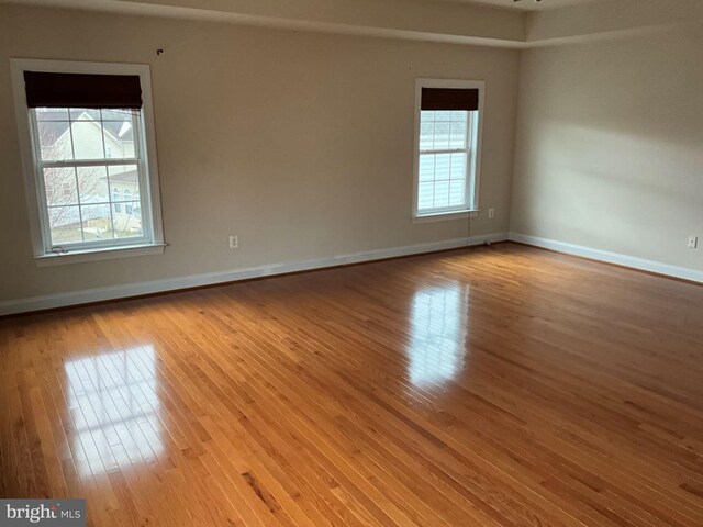 unfurnished room featuring baseboards and hardwood / wood-style floors