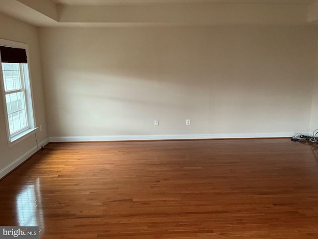 spare room with wood finished floors and baseboards