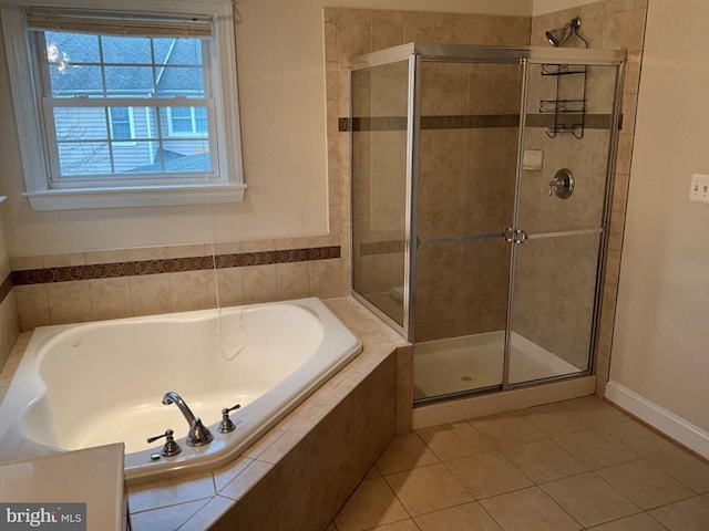 full bathroom featuring a stall shower, a bath, and tile patterned floors