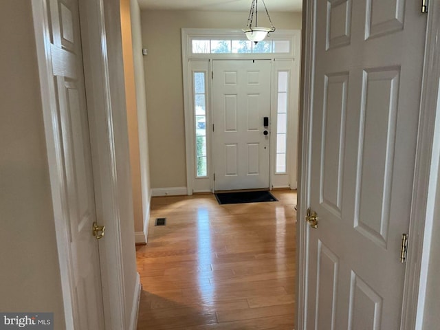 entrance foyer featuring visible vents, light wood-style flooring, and baseboards