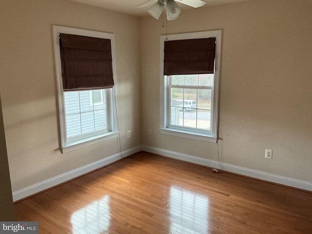 empty room with ceiling fan, wood-type flooring, and baseboards