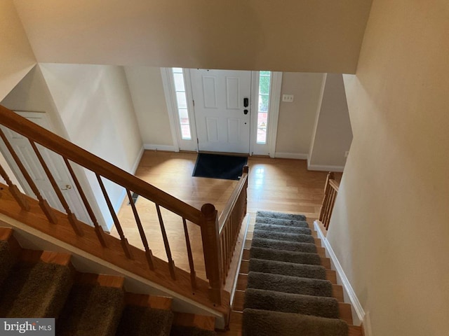 entrance foyer featuring stairs, wood finished floors, and baseboards