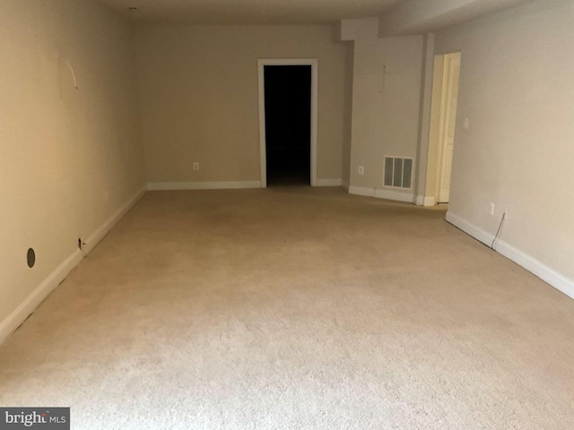 unfurnished room with baseboards, visible vents, and light colored carpet