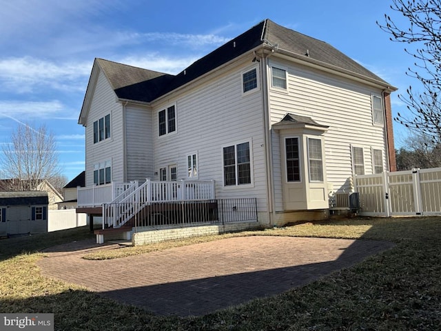 back of house featuring a gate, fence, and a deck