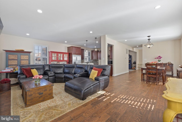 living area featuring recessed lighting, a chandelier, baseboards, and wood finished floors