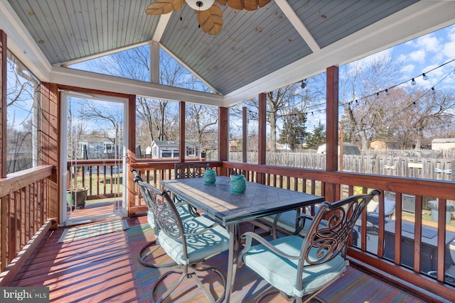 sunroom with a ceiling fan and vaulted ceiling