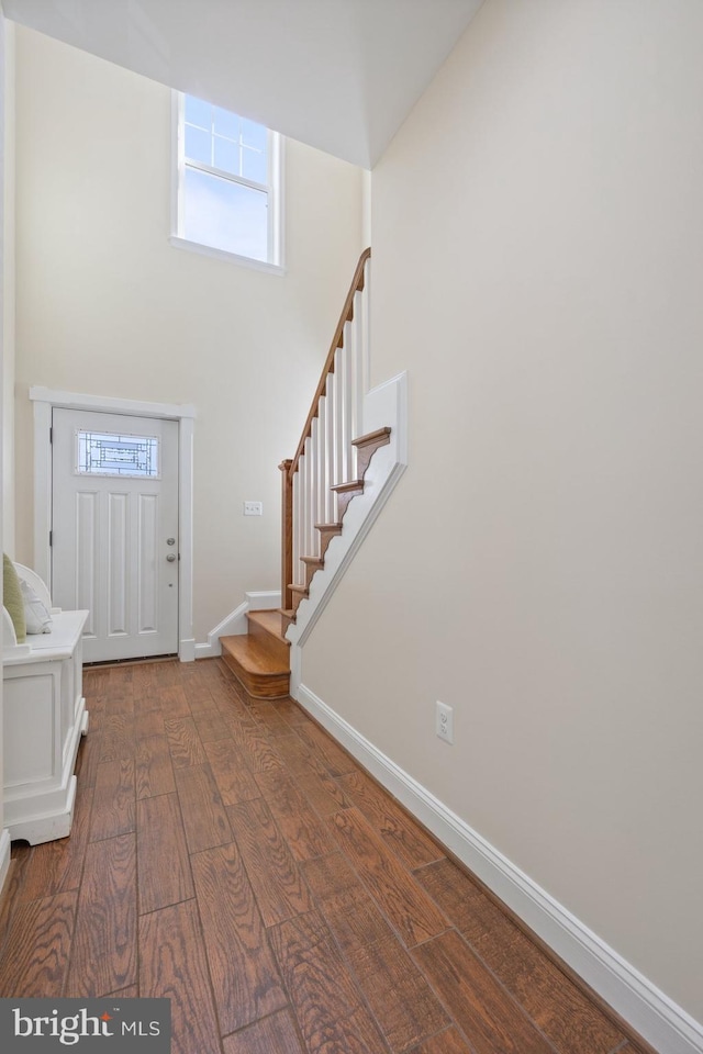 entrance foyer with stairs, baseboards, and hardwood / wood-style floors