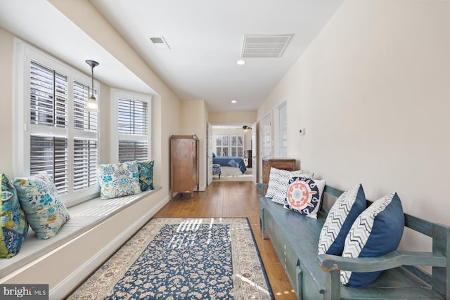 hall featuring recessed lighting, wood finished floors, visible vents, and baseboards