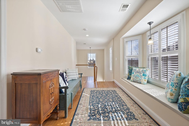 interior space with visible vents, a notable chandelier, and wood finished floors