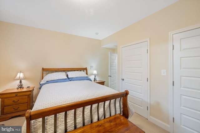 bedroom with baseboards and light carpet