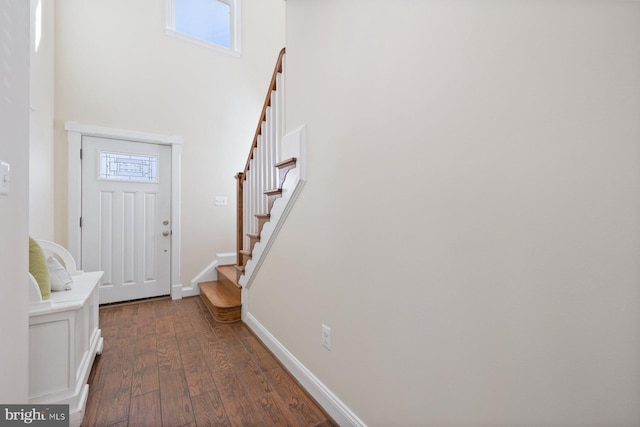 entryway with dark wood finished floors, stairway, a healthy amount of sunlight, and baseboards