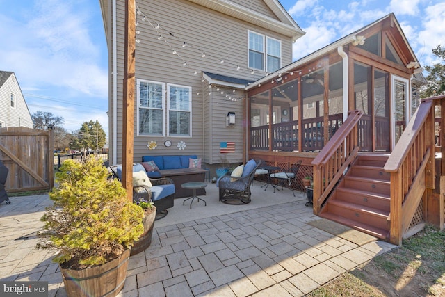 back of house featuring a patio, a gate, fence, a sunroom, and an outdoor hangout area