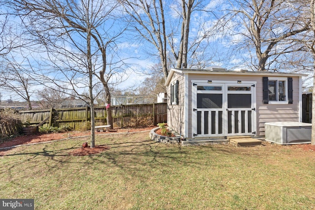 view of yard featuring a storage unit, an outdoor structure, and a fenced backyard