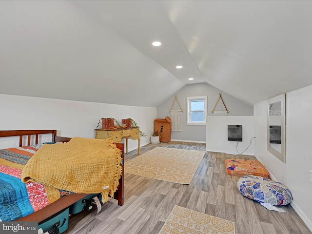 bedroom with recessed lighting, wood finished floors, baseboards, vaulted ceiling, and heating unit