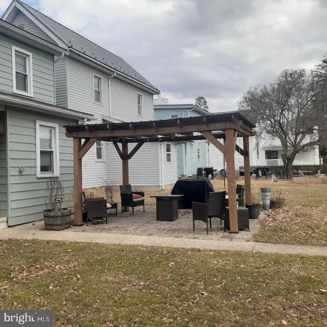 rear view of property featuring metal roof, a pergola, and a patio