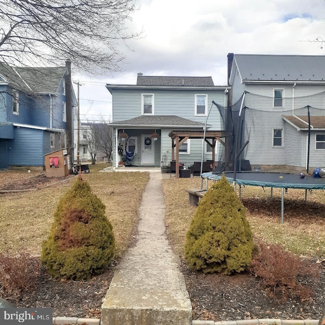 view of front of house with a trampoline, a porch, and a shingled roof