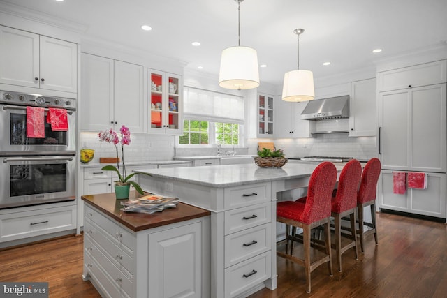 809 Cornell St, Fredericksburg, VA 22401 - kitchen featuring white cabinets, stainless steel double oven, wall chimney exhaust hood, a center island, and backsplash